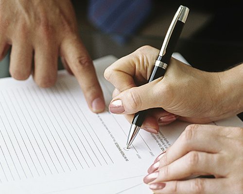 Businessman and woman signing documents,close-up of hands